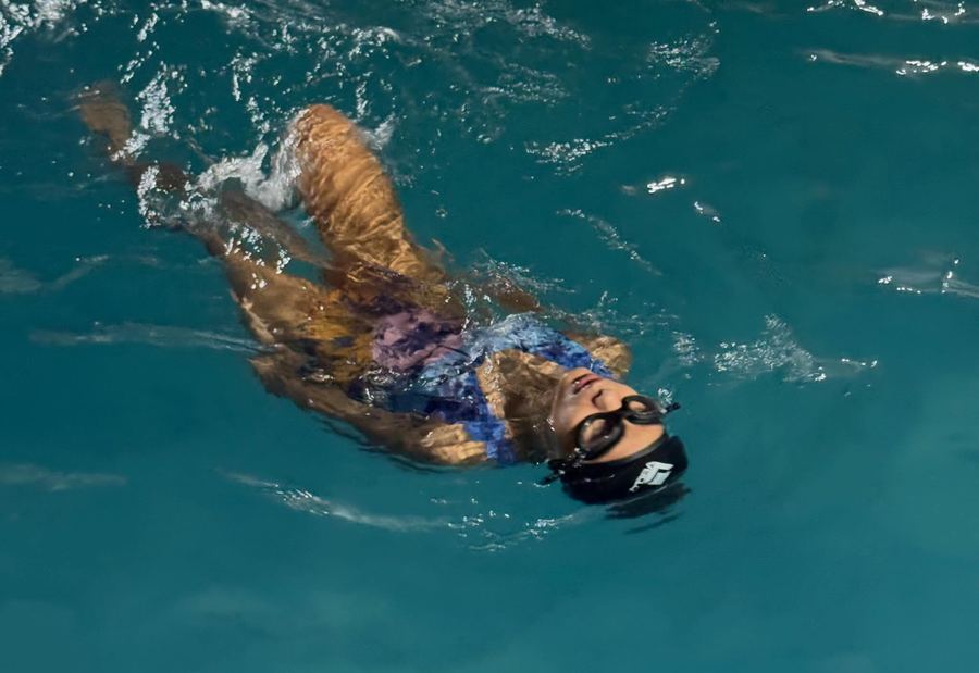 Aluna nadando de costas na piscina da Arena CS23