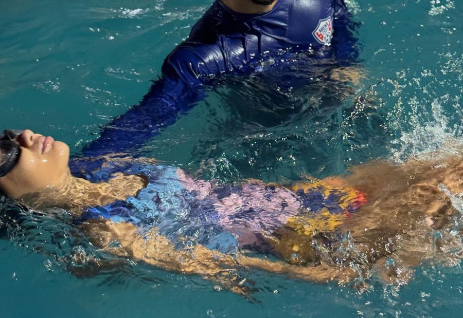 Aula de natação com prancha na piscina da arena